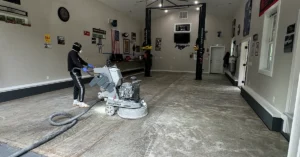 Epoxy flooring contractor diamond grinding a concrete garage floor during surface prep